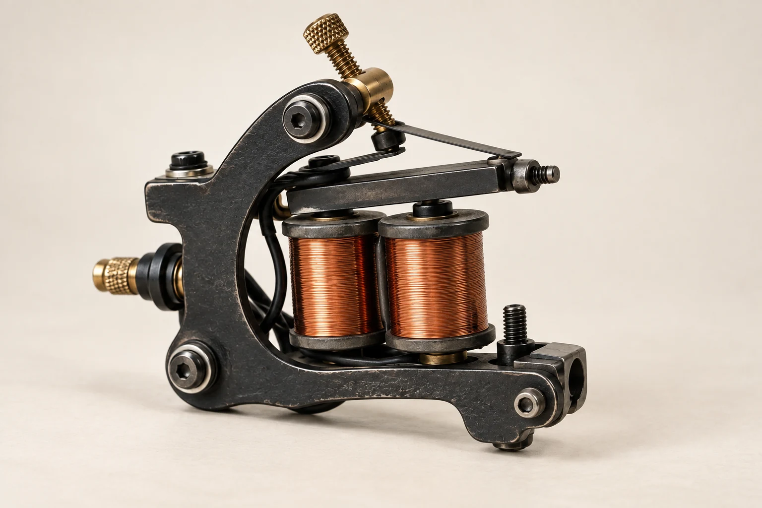 Vereinfachte Coil-Maschine mit schwarzem Rahmen, zwei kupferfarbenen Spulen und oberem Federmechanismus, ohne Griffstück und Nadel.